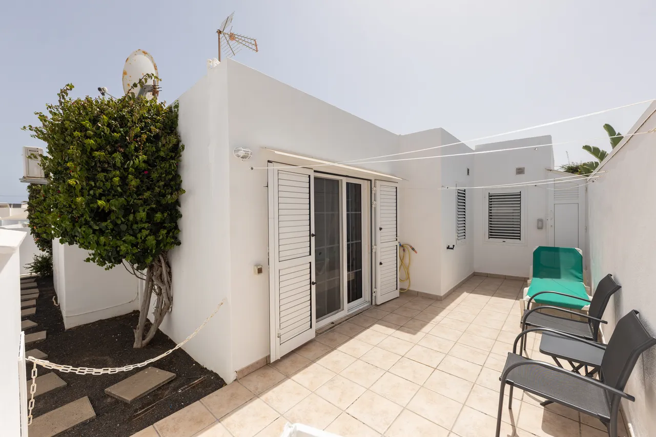 Weißer Bungalow mit Terrasse und Terrassentüren