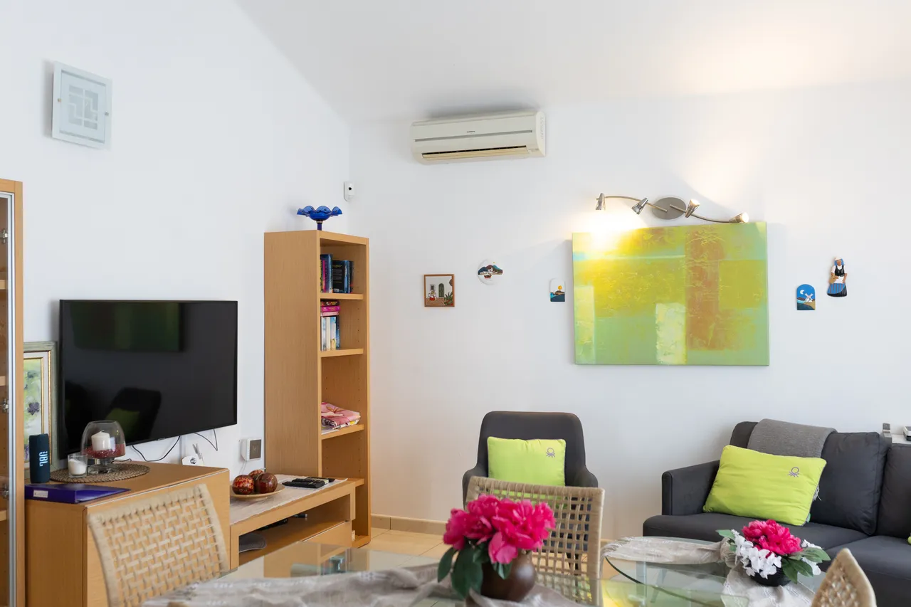 Wohnzimmer mit Flat-TV und Sofa