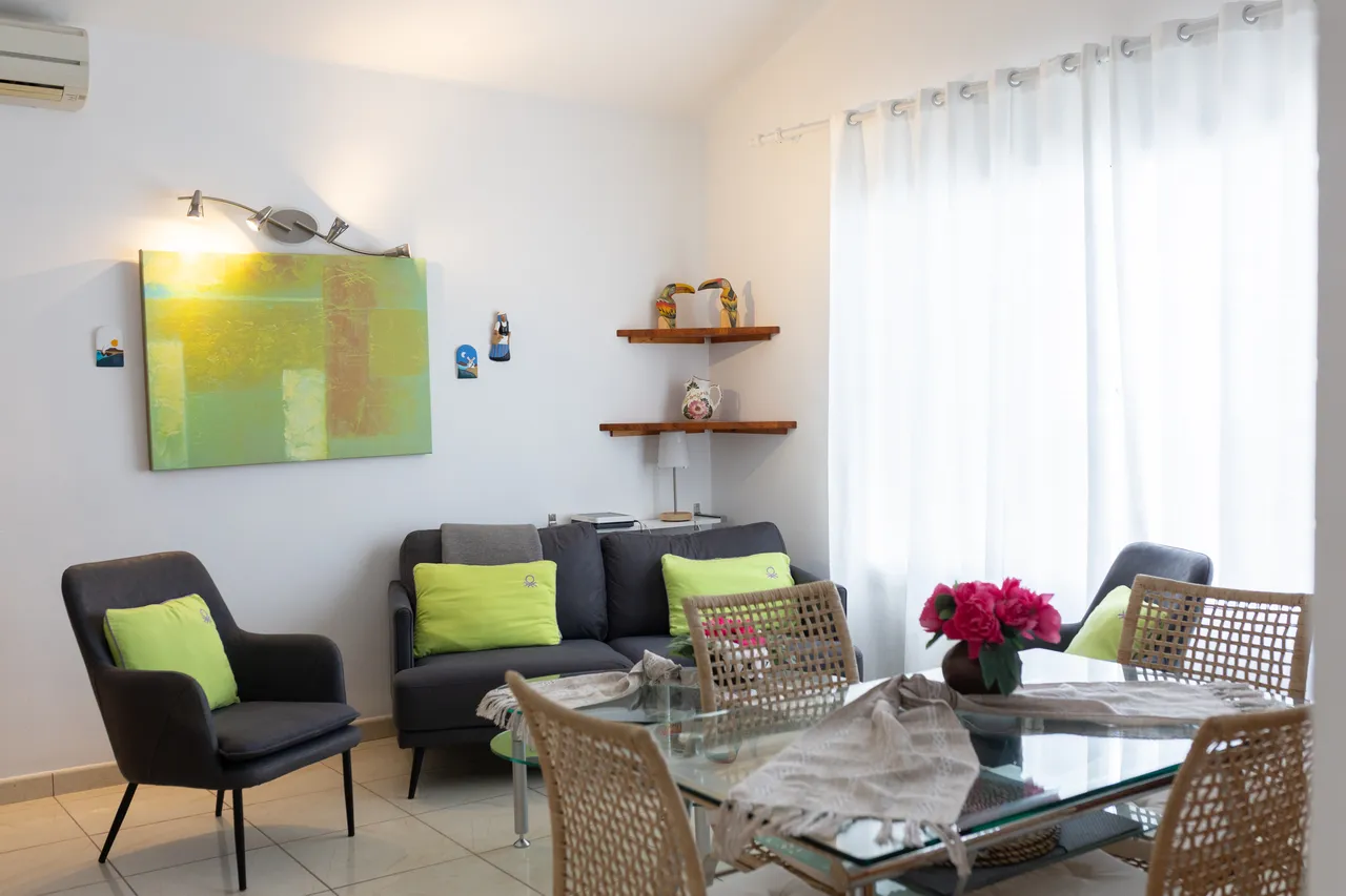 Heller Wohnbereich mit Sofa, Kunst und Esstisch